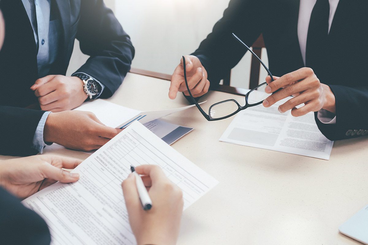 Legal professionals reviewing commercial litigation documents during a corporate consultation.