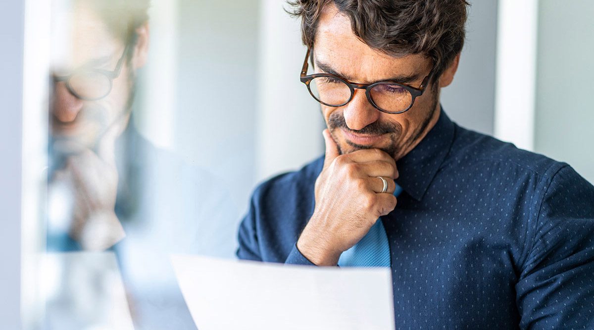 Business professional reviewing financial documents during a forensic investigation consultation.